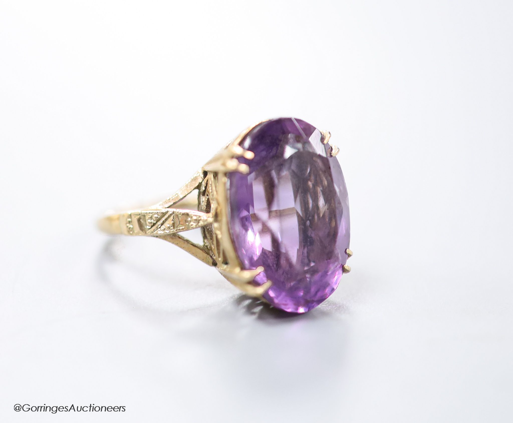 A 9ct gold and oval cut amethyst set dress ring, size H